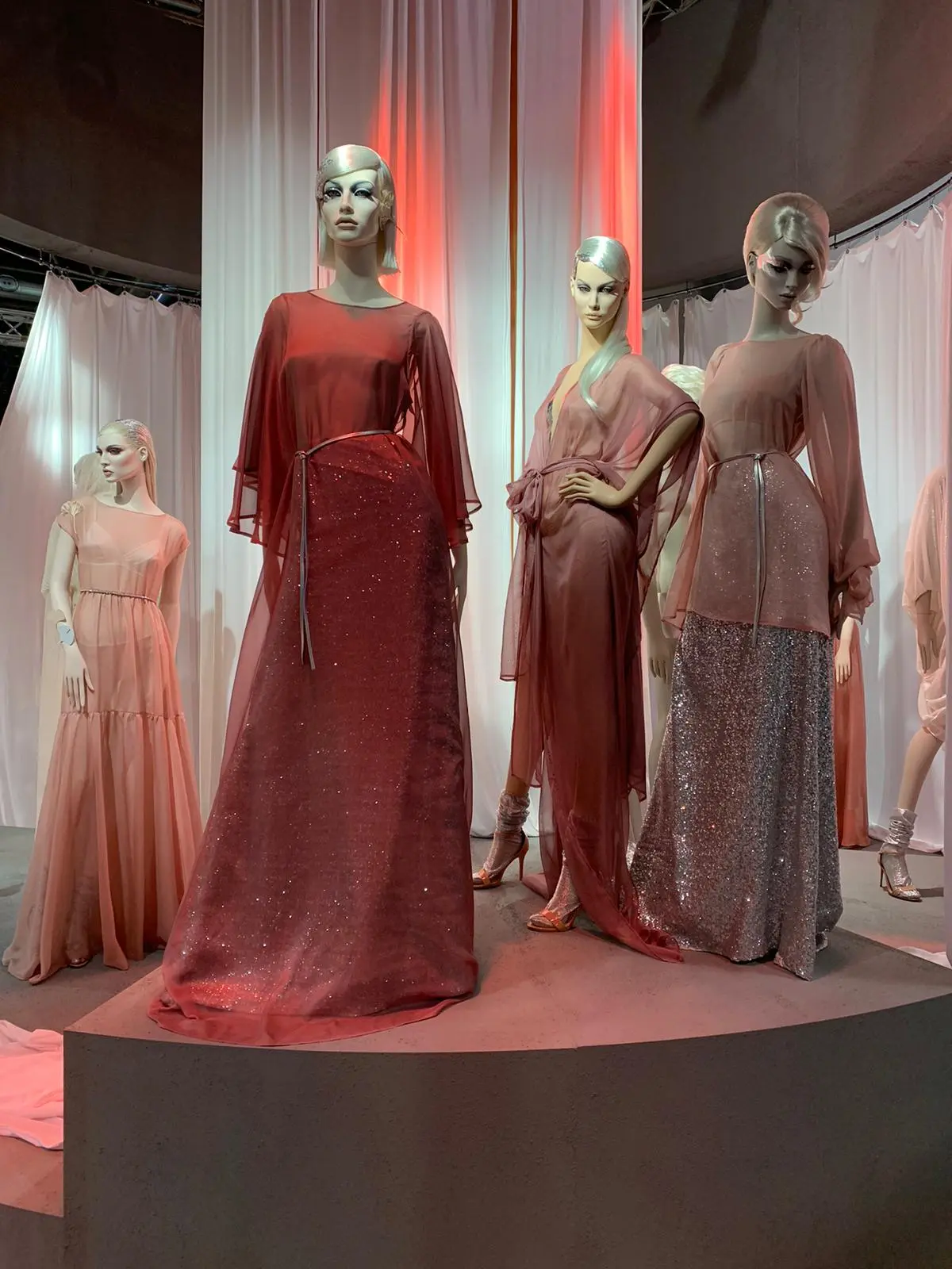 Esposizione di Moda con Manichini Femminili e Abiti Rossi e Rosa.